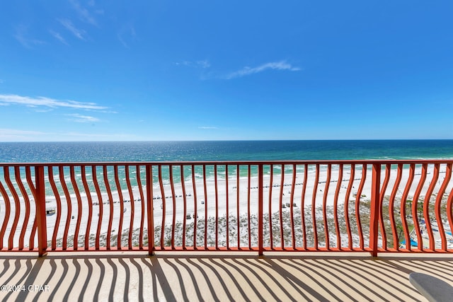 balcony featuring a view of the beach and a water view