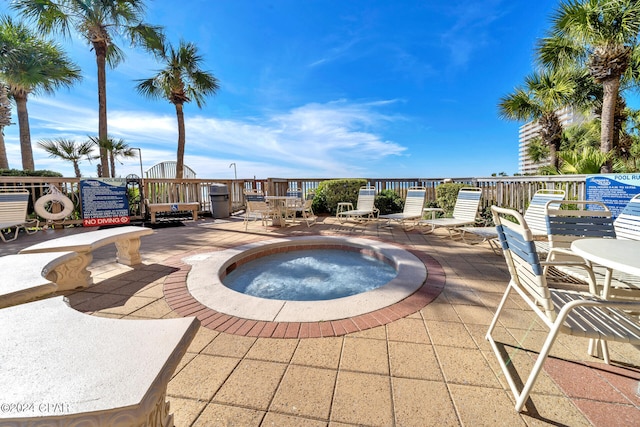 view of swimming pool featuring a patio and a hot tub