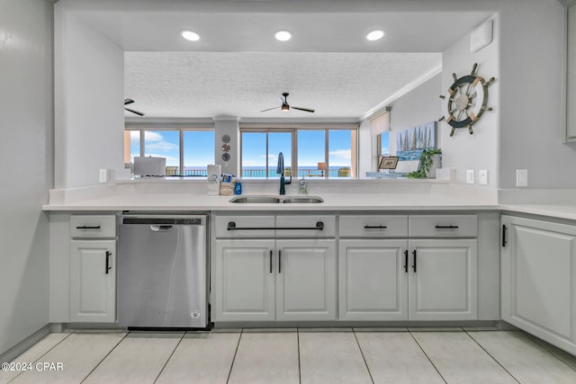 kitchen with dishwasher, light tile floors, sink, and a textured ceiling