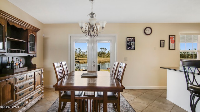 dining area with french doors, a chandelier, and light tile patterned flooring