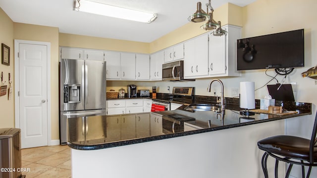 kitchen with dark stone counters, kitchen peninsula, stainless steel appliances, and sink