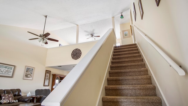 stairs featuring ceiling fan and high vaulted ceiling