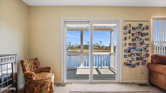 doorway featuring plenty of natural light and light carpet