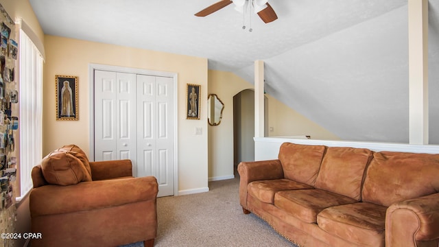 carpeted living room with lofted ceiling and ceiling fan