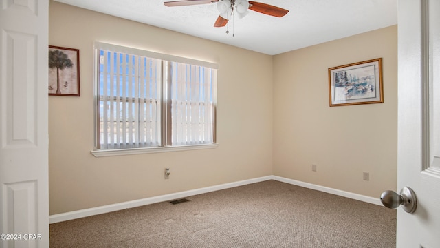 spare room with ceiling fan and carpet