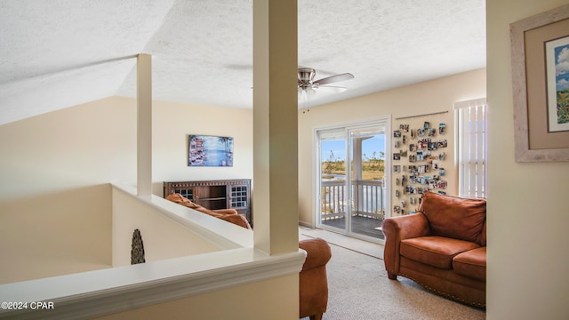 carpeted living room with lofted ceiling, ceiling fan, a fireplace, and a textured ceiling