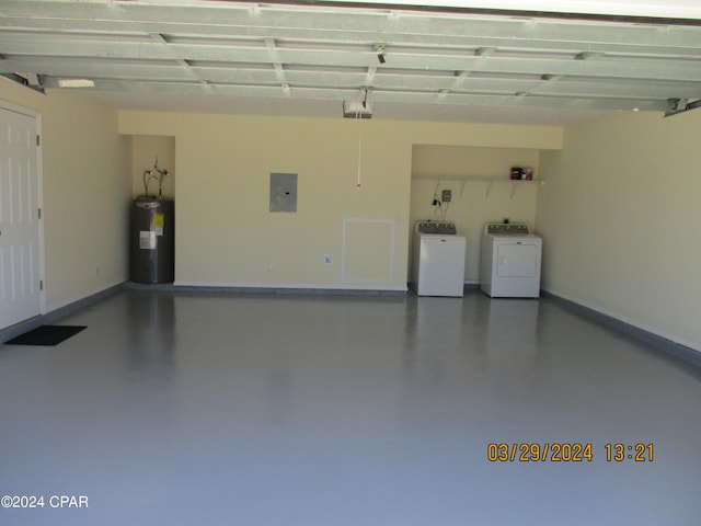 garage featuring a garage door opener, electric panel, independent washer and dryer, and water heater