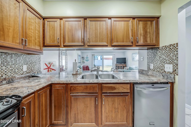 kitchen with stainless steel appliances, light stone countertops, backsplash, and sink