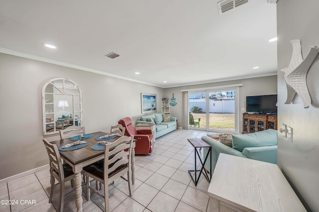 dining space featuring light tile patterned flooring and crown molding