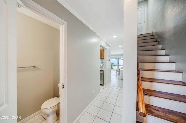 stairway featuring ornamental molding and tile patterned floors