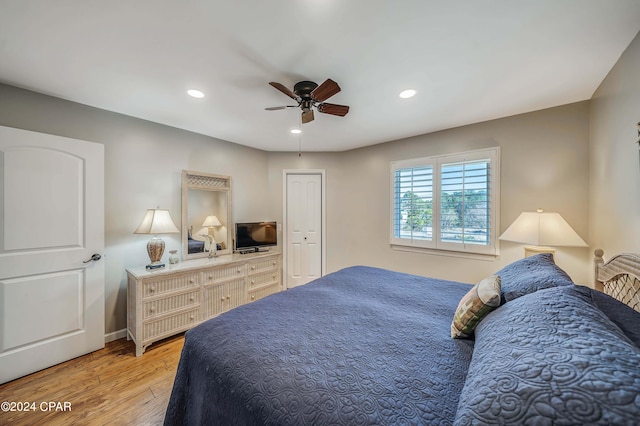 bedroom with ceiling fan, light hardwood / wood-style flooring, and a closet