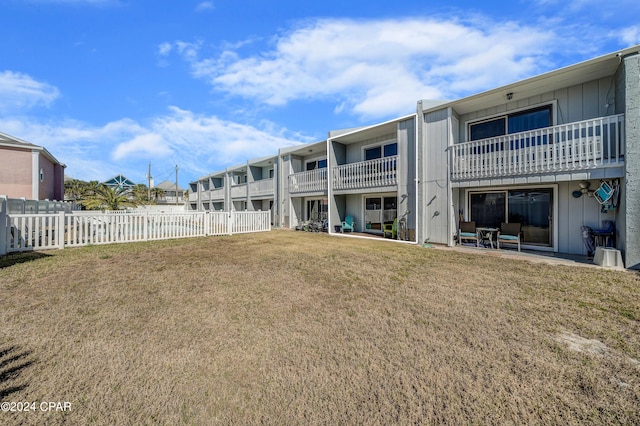 exterior space featuring a balcony, a lawn, and a patio area