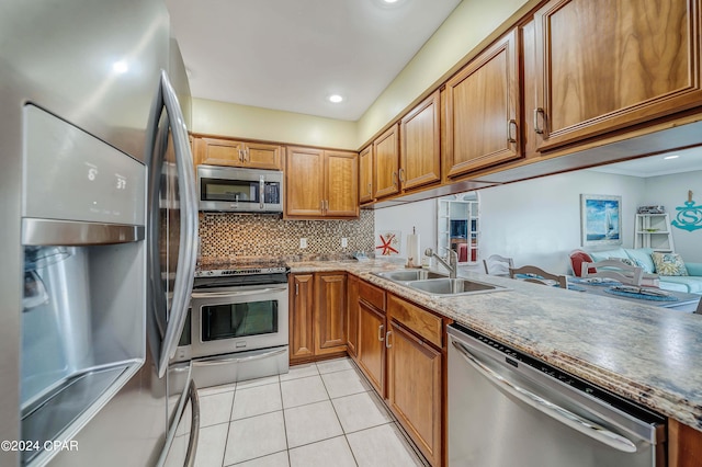 kitchen featuring stainless steel appliances, backsplash, light tile patterned flooring, and sink