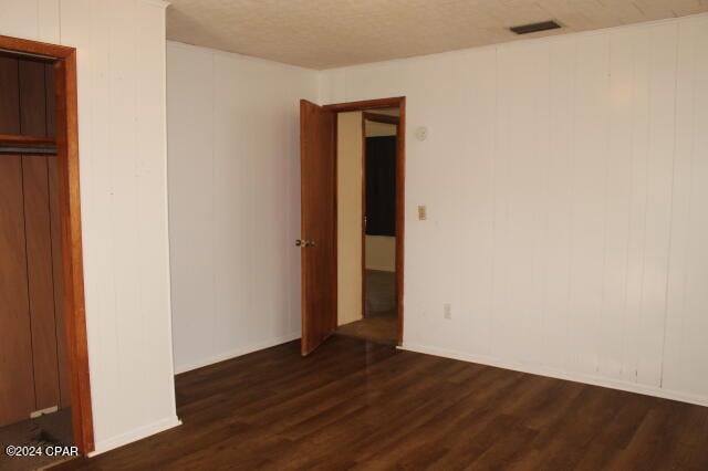 unfurnished bedroom with dark wood-type flooring