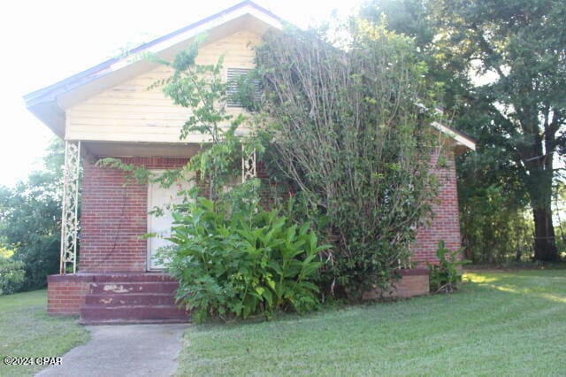 view of property hidden behind natural elements with a front lawn