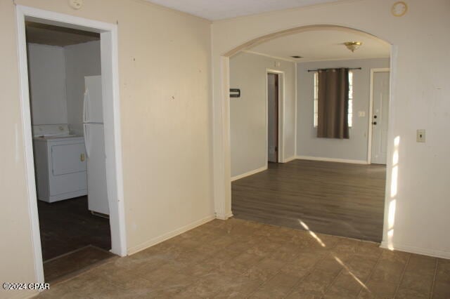 hallway featuring washer / dryer and dark tile floors