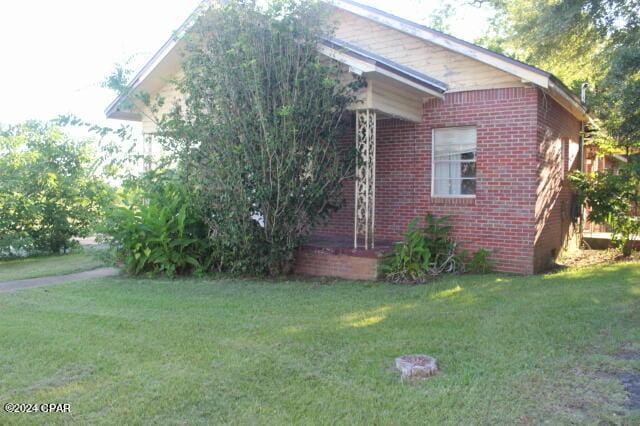 view of side of property with a yard