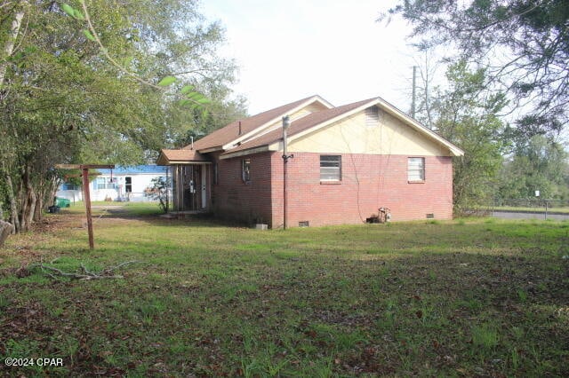 view of side of home featuring a lawn