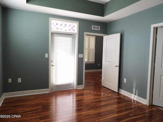 interior space with dark hardwood / wood-style flooring and a healthy amount of sunlight