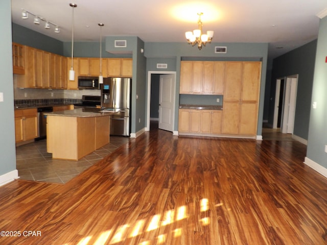 kitchen featuring a center island, hanging light fixtures, dark hardwood / wood-style flooring, stainless steel appliances, and a chandelier