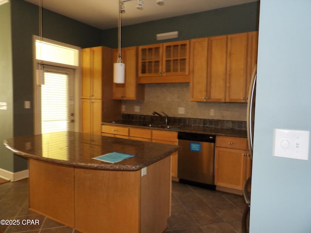 kitchen with sink, decorative light fixtures, dark tile patterned flooring, dishwasher, and a kitchen island