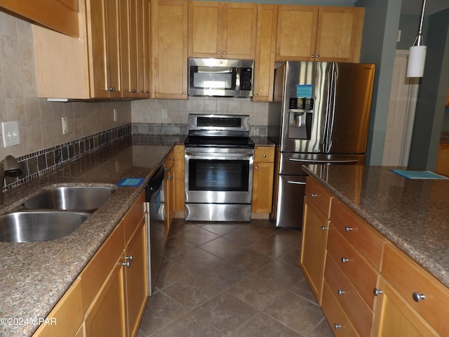 kitchen with decorative light fixtures, backsplash, stainless steel appliances, and sink