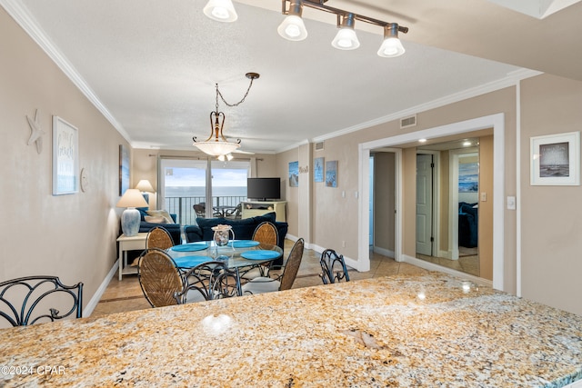 dining room with light tile floors, track lighting, a textured ceiling, and crown molding