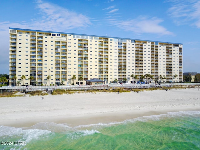 view of building exterior with a view of the beach and a water view