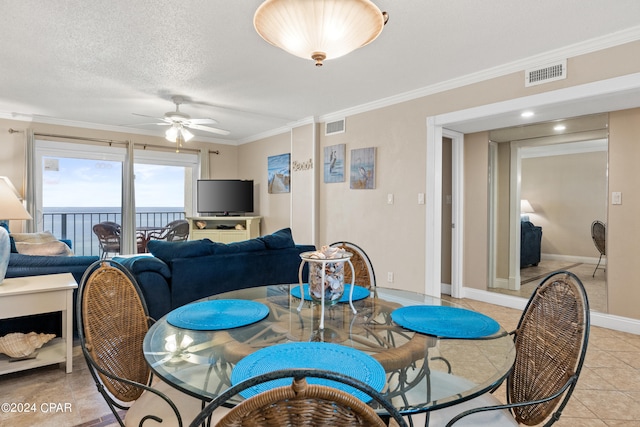 dining room with light tile floors, ornamental molding, ceiling fan, and a textured ceiling