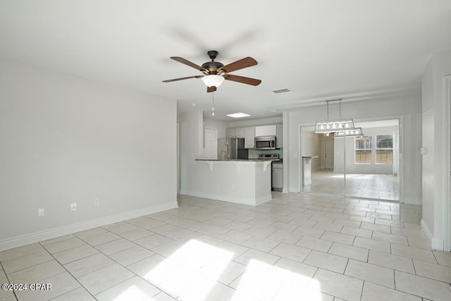 unfurnished living room with light tile flooring and ceiling fan