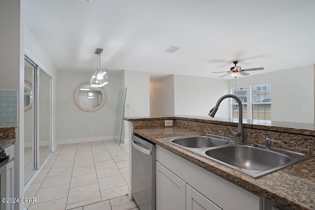 kitchen featuring pendant lighting, dark stone counters, light tile flooring, ceiling fan, and dishwasher