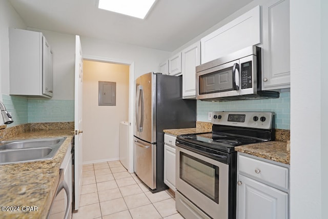 kitchen featuring stainless steel appliances, light tile flooring, white cabinets, backsplash, and sink