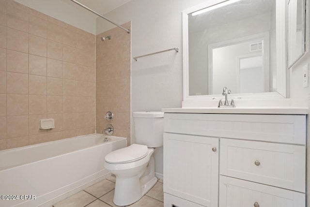 full bathroom featuring tile floors, tiled shower / bath combo, toilet, and vanity