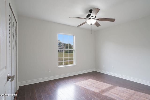 spare room with dark hardwood / wood-style flooring and ceiling fan