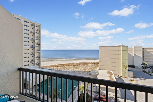 balcony with a water view and a view of the beach