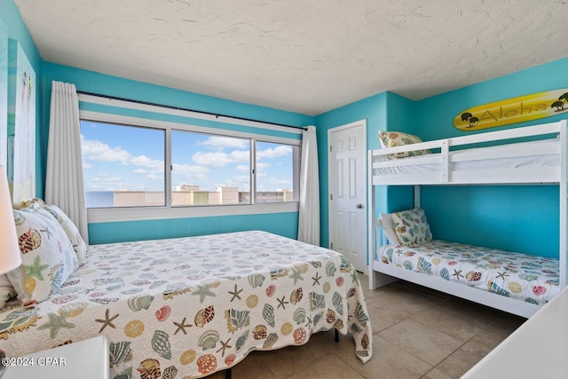 bedroom with tile floors and a textured ceiling