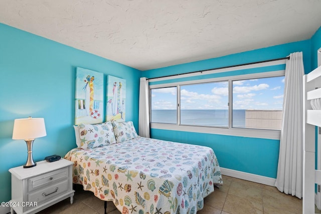 bedroom featuring tile flooring and a water view