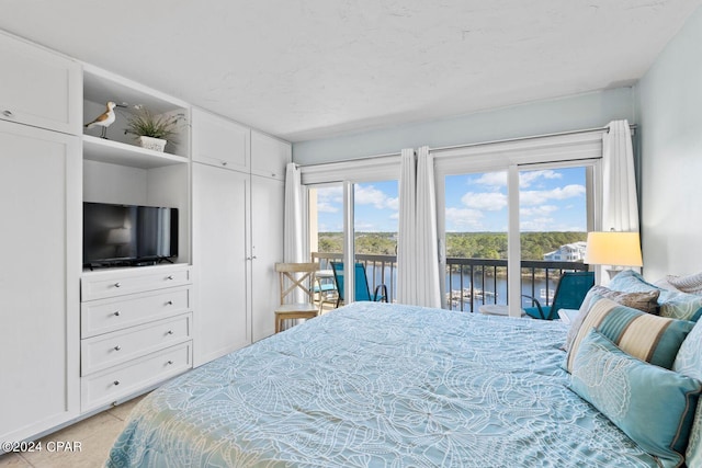 tiled bedroom with a water view and access to exterior