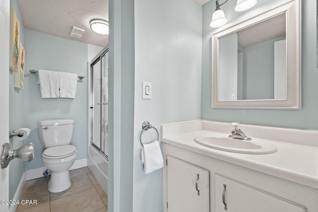 full bathroom with tile flooring, vanity, toilet, and bath / shower combo with glass door