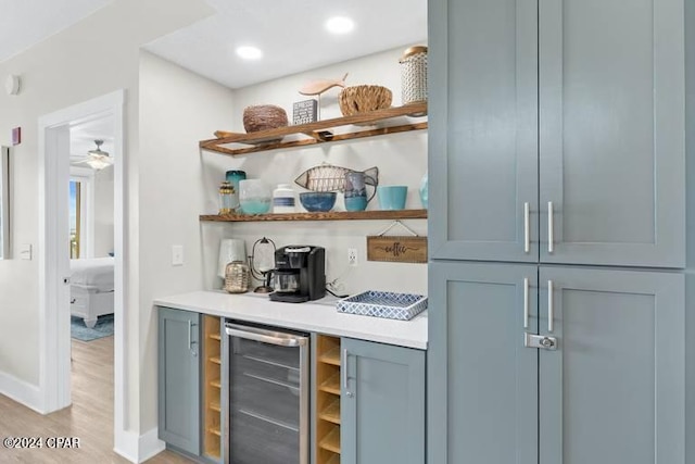 bar featuring light wood-style flooring, recessed lighting, beverage cooler, baseboards, and a dry bar