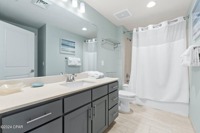 bathroom featuring shower / bath combination with curtain, visible vents, vanity, and toilet