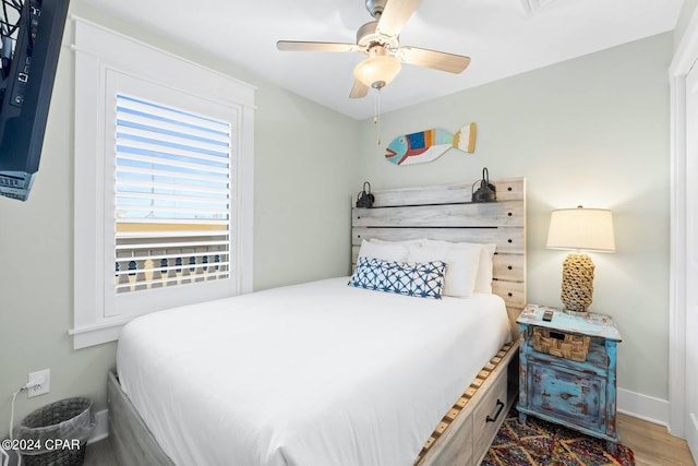 bedroom featuring ceiling fan, baseboards, and wood finished floors