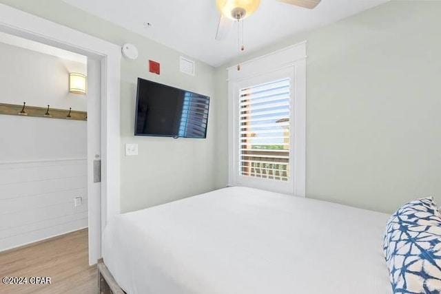 bedroom with a ceiling fan, visible vents, and wood finished floors