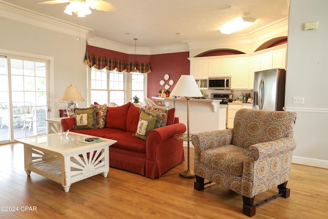 living room with ceiling fan, light hardwood / wood-style flooring, and crown molding