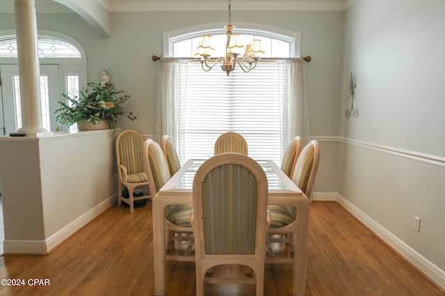 dining room with a wealth of natural light, ornamental molding, and hardwood / wood-style flooring