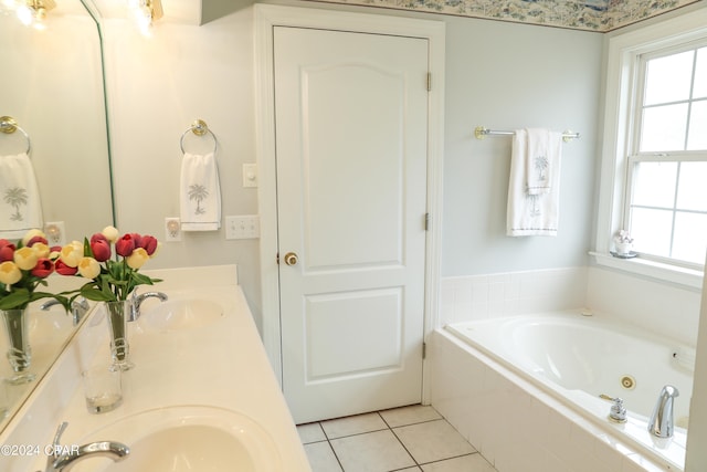 bathroom featuring tile flooring, a relaxing tiled bath, vanity with extensive cabinet space, and dual sinks