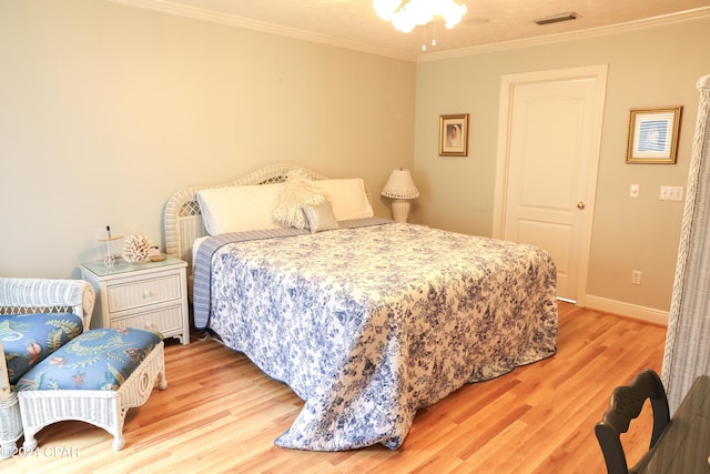 bedroom with ornamental molding and hardwood / wood-style floors