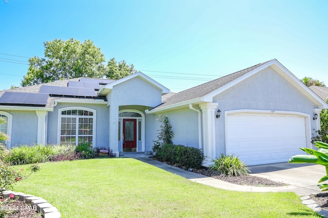 ranch-style home with a front lawn, a garage, and solar panels