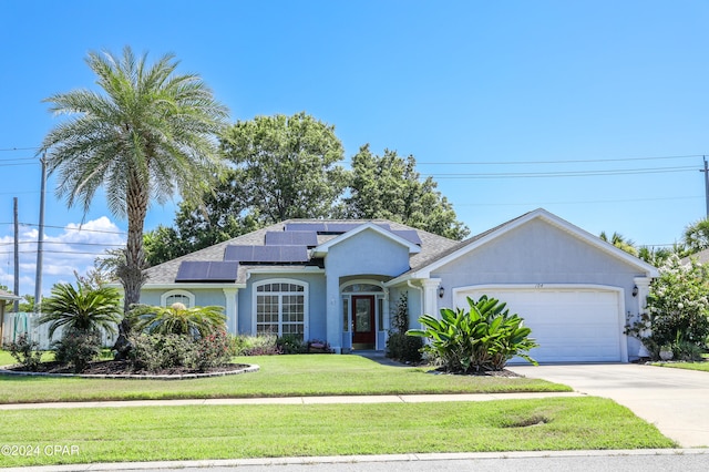 ranch-style home featuring a front yard, a garage, and solar panels