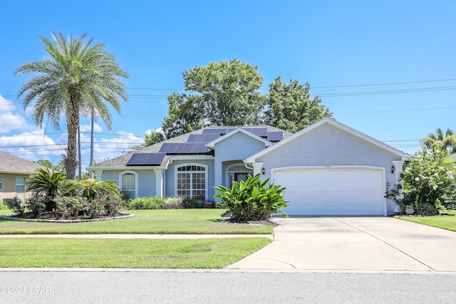 single story home featuring a garage, a front lawn, and solar panels